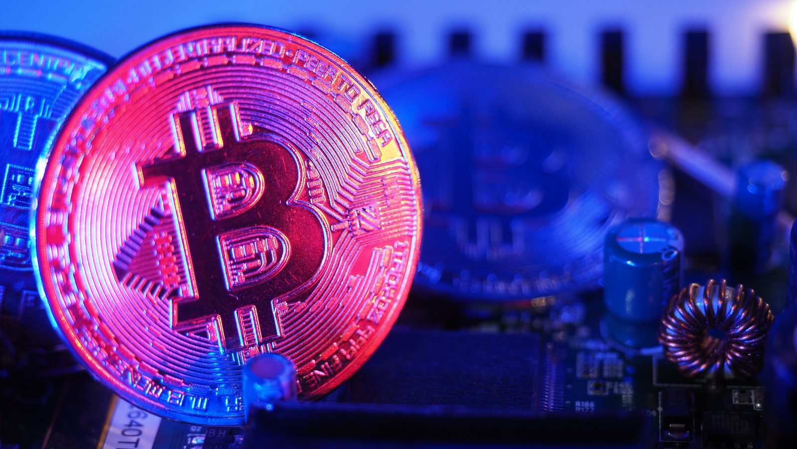 A digital currency token lit in neon on a circuit board